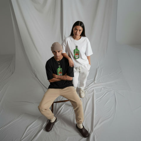 Two people wearing t-shirts with jagermeister bottle graphics against a plain background